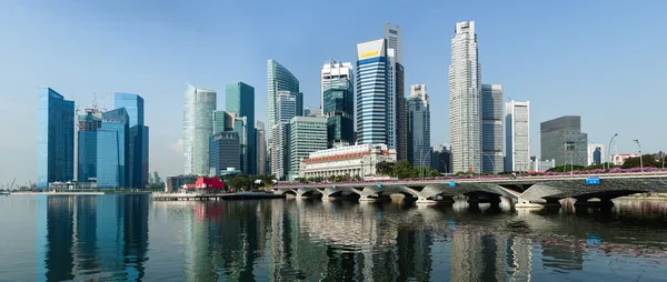 Szingapúr modern felhőkarcolói a Marina-öböl partján, tükröződve a vízben.